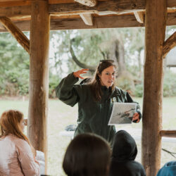 volunteer in fish and wildlife uniform teaches group of students