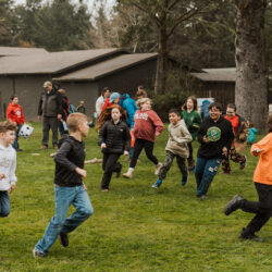 children run around outside in the grass
