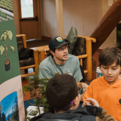 volunteer in green shirt talks to a student