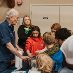 volunteer shows group of students about water safety